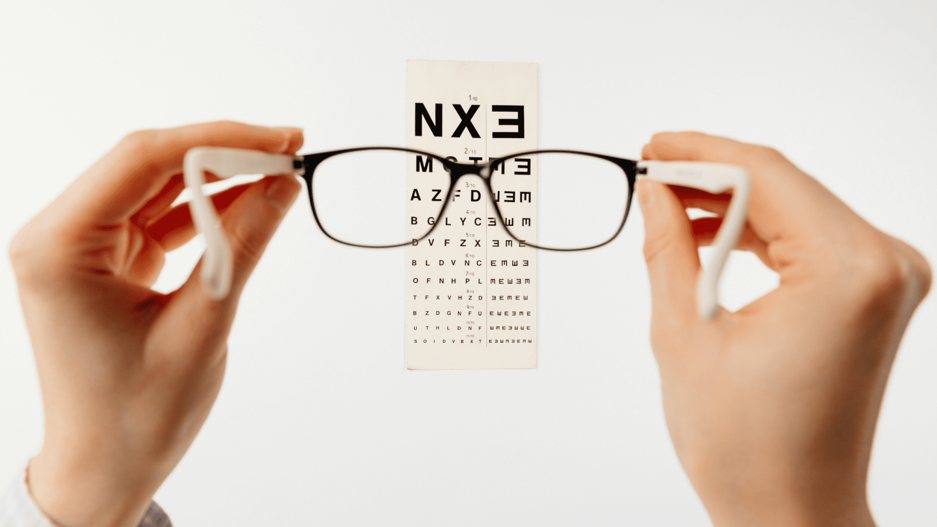 https://www.eyecentersurgeons.com/wp-content/uploads/2022/07/eye-chart-with-person-holding-glasses.png